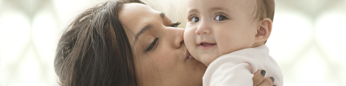 Mother holding and kissing a baby on the cheek