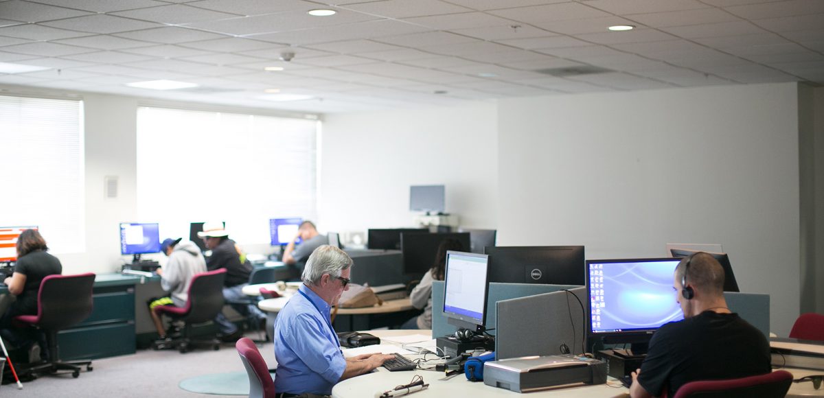 Two people use computers in Wayfinder's assistive technology training lab in Los Angeles
