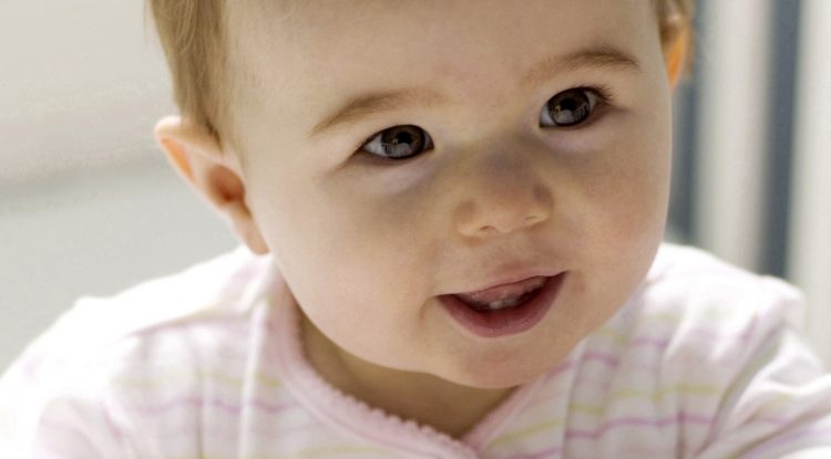 A baby in a crib smiling