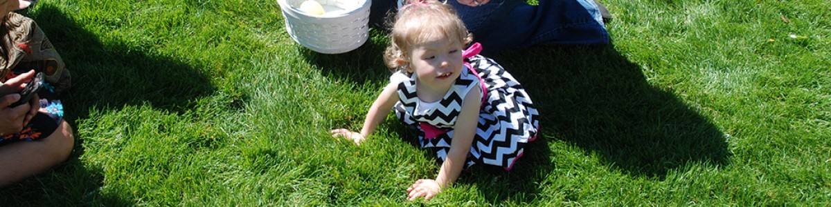 Baby Mackenzie crawls in the grass during a beeper egg hunt