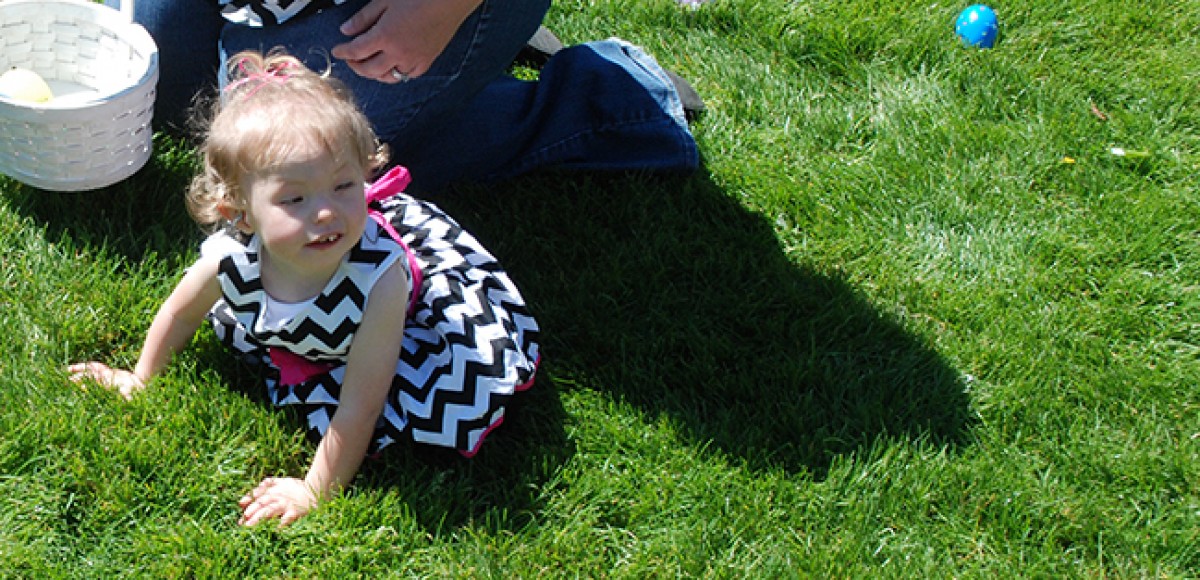 Baby Mackenzie crawls in the grass during a beeper egg hunt