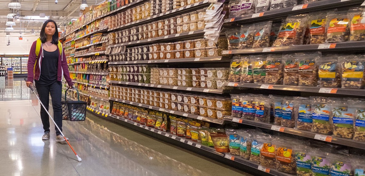 A student of The Hatlen Center independently guides herself through a grocery store using a white cane