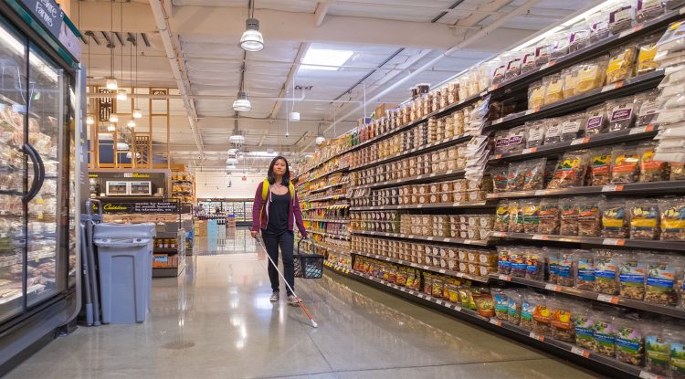 A student of The Hatlen Center independently guides herself through a grocery store using a white cane