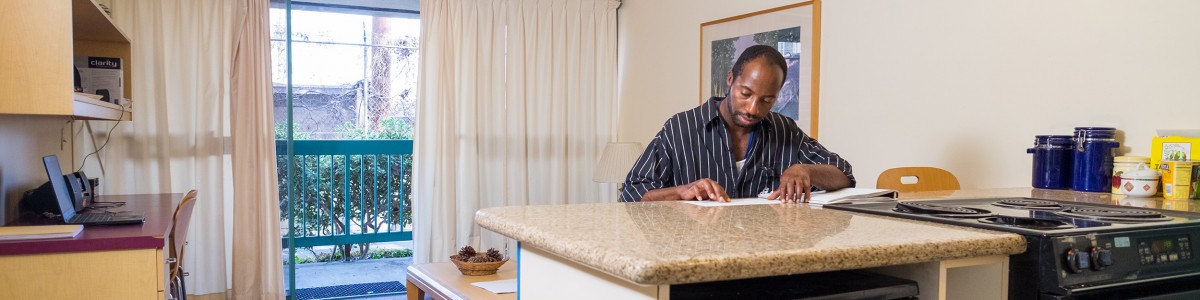 An adult who is blind reads Braille while sitting at a countertop