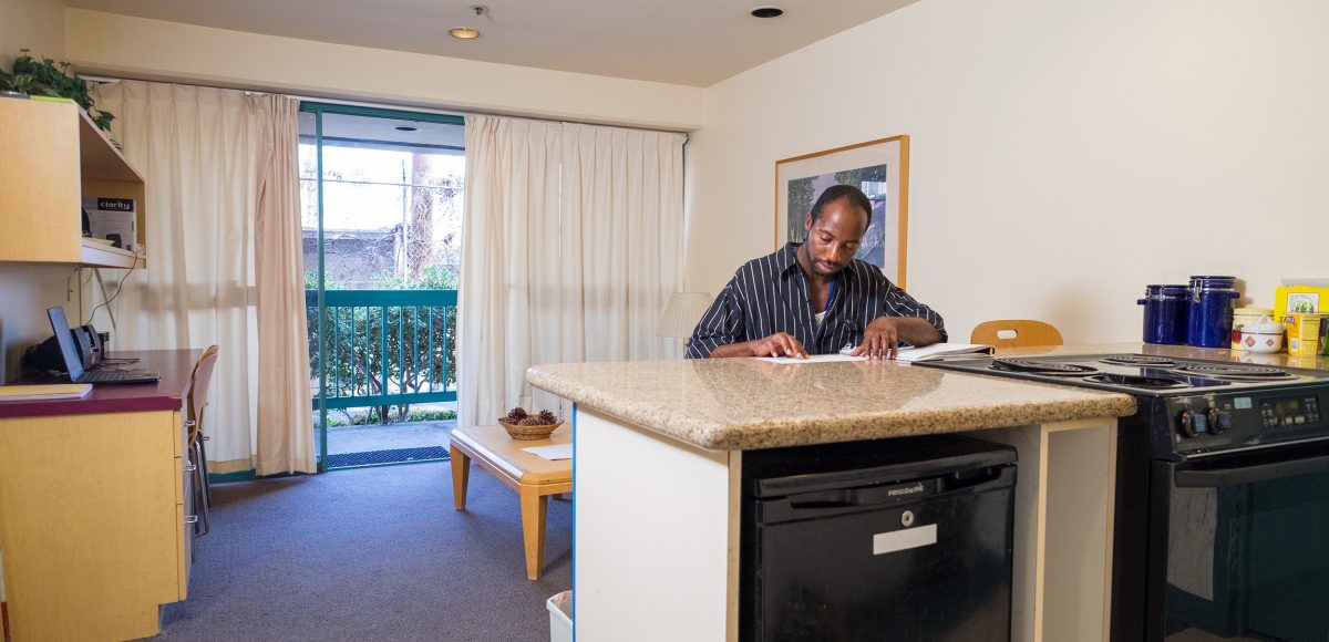 An adult who is blind reads Braille while sitting at a countertop