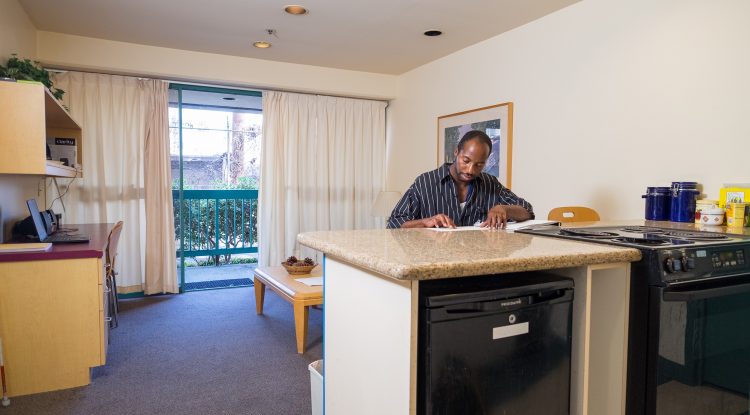 An adult who is blind reads Braille while sitting at a countertop