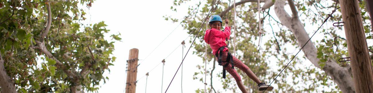 Camper doing ropes course up in the trees