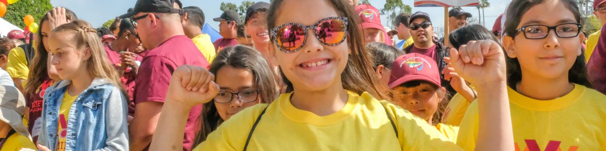 girl raising her arms and smiling at wayfinder paralympics