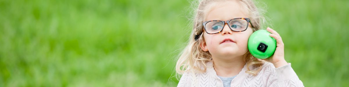 Little girl listens to a beeping egg at our Beeper Egg Hunt