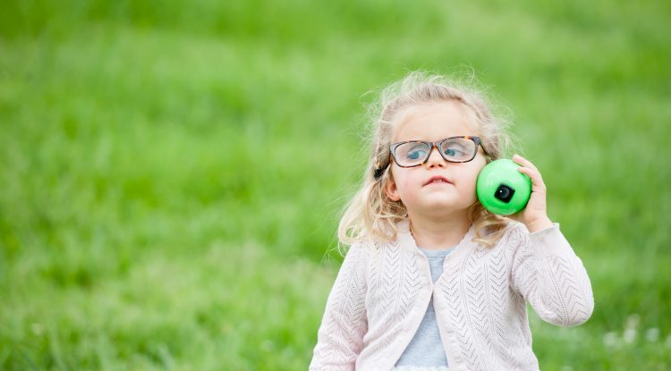 Little girl listens to a beeping egg at our Beeper Egg Hunt