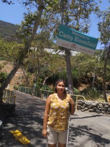 Evelyn smiles at entrance of camp