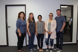 Young woman intern smiling with Cleanlogic staff members