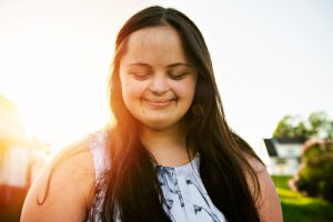 young girl with eyes closed smiling in sunlight