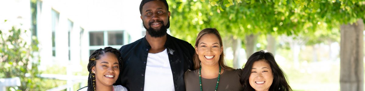 four Wayfinder staff members smiling and standing with arms around each other