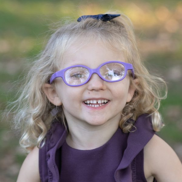 little girl with glasses smiling