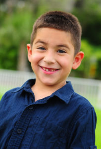 Boy with missing tooth smiles at camera