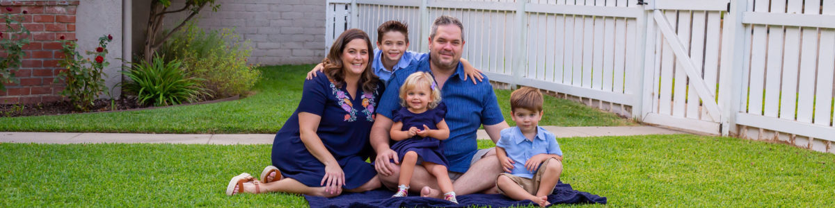 family of five sitting on grass