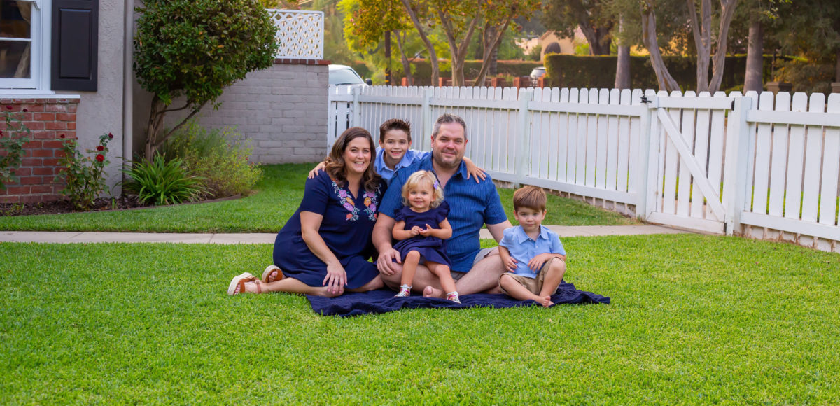 family of five sitting on grass