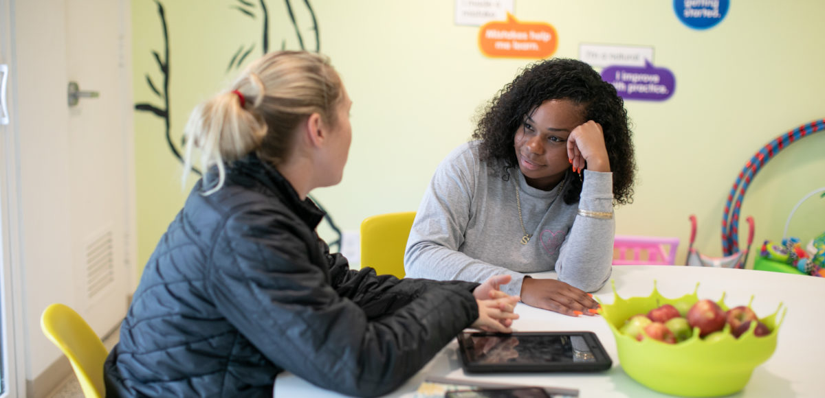 counselor sitting at table with youth