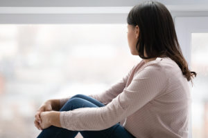 young girl looks out window