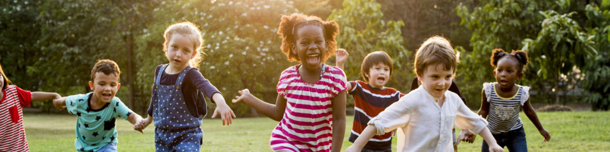 gorup of happy kids running on grass