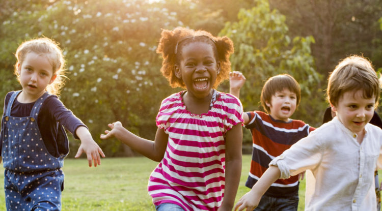 gorup of happy kids running on grass