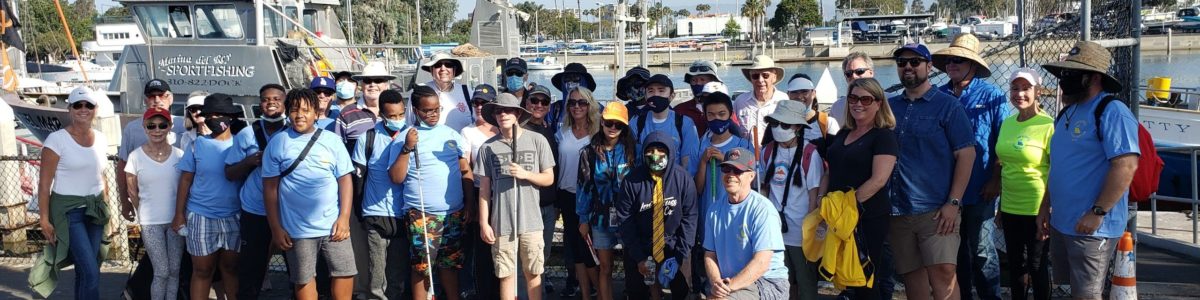 large group posing in front of marina