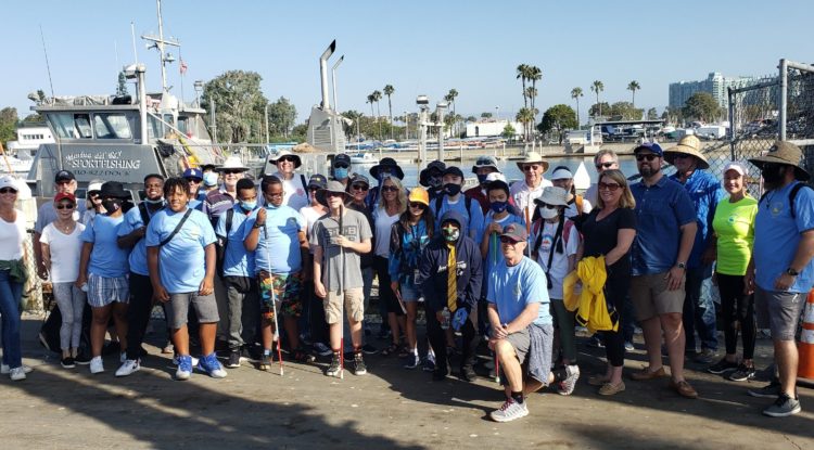 large group posing in front of marina