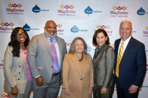 panelists and president pose with wayfinder and aspen logos in the background