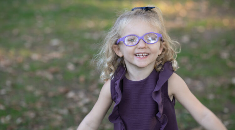 Toddler wearing glasses smiling